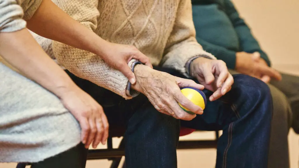 senior man sat with a ball in his hand