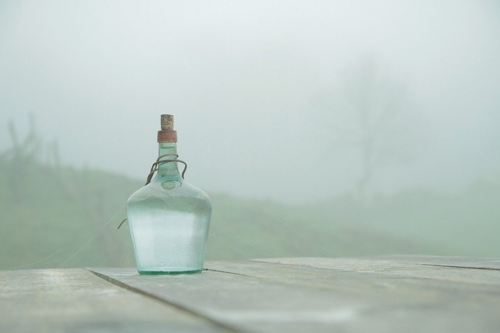 glass bottled water on a table in a foggy environment